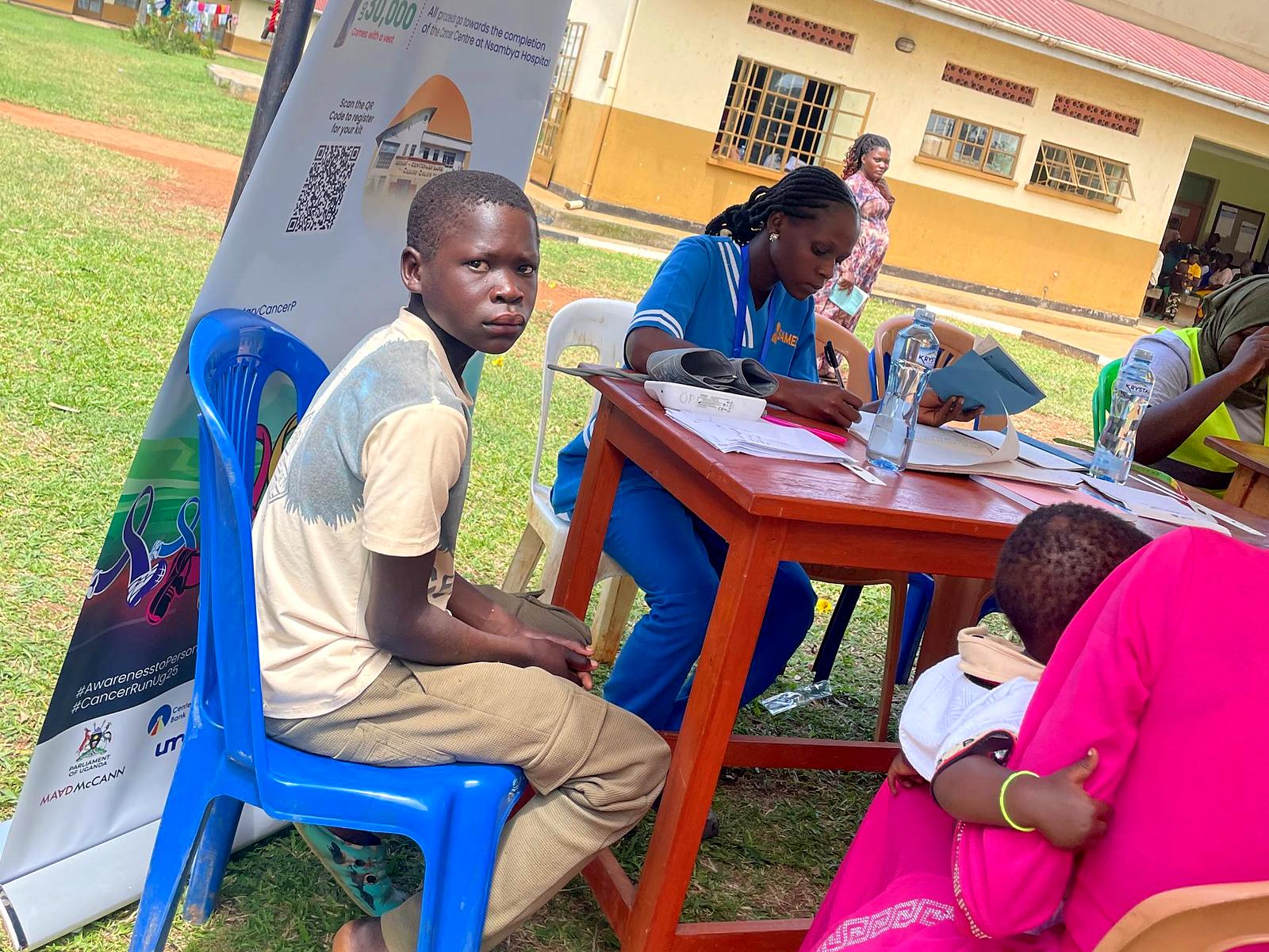 A Sameday nurse checks a boy's blood pressure at a community health day