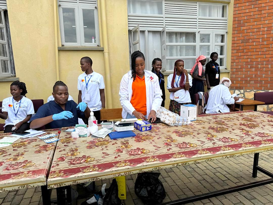 Health workers in gloves prepare rapid diagnostic test kits at a community screening table