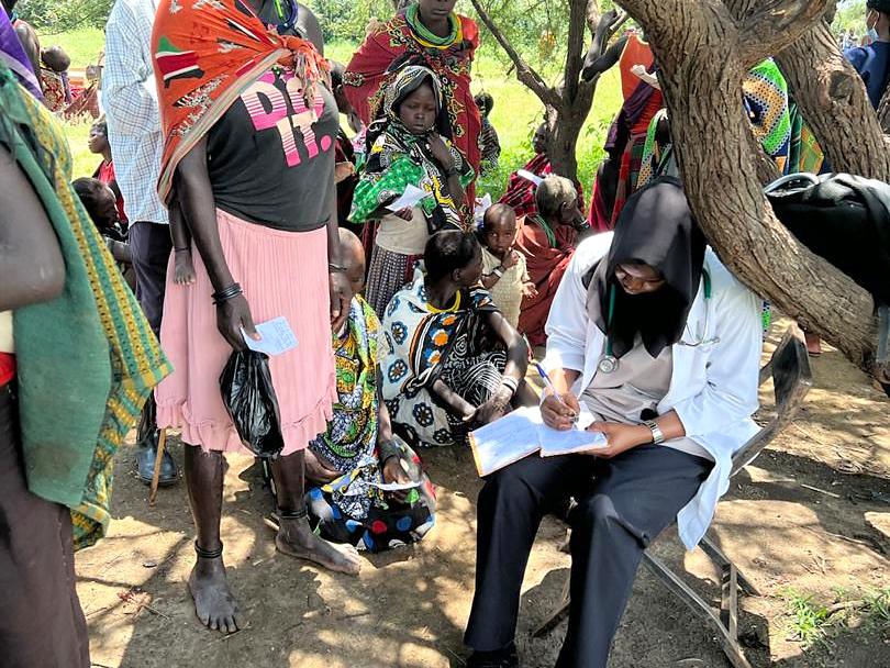 A community health session held under a tree